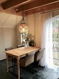 a dining room table with chairs and a chandelier at RiemersHof in Ermelo