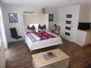 1 dormitorio con 1 cama, 1 mesa y 1 silla en Ferienwohnung MOEWE, en Herdwangen-Schönach