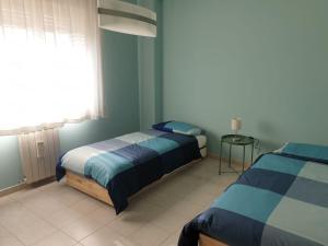 - une chambre avec 2 lits et une fenêtre dans l'établissement COCO Apartments, à Catane