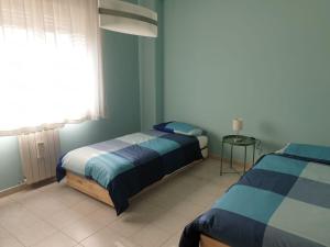 sypialnia z dwoma łóżkami i oknem w obiekcie COCO Apartments w Katanii