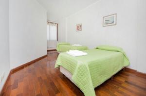 1 dormitorio con 2 camas verdes y suelo de madera en Departamento enorme sobre Cañada Patio Olmos en Córdoba