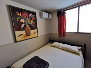 um quarto com uma cama com um vaso na parede em Blue Ocean Apartments Chipipe em Salinas