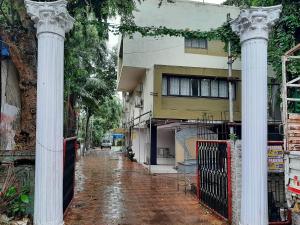 an empty street with two columns in front of a building at Hotel Golden Palms in Mumbai