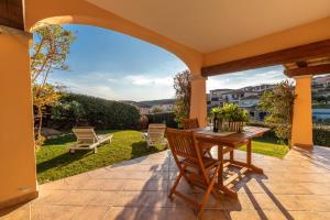 un patio con tavolo e sedie in legno di Poggio dei fiori a Olbia