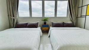 two beds in a room with two windows at No.8 The Cube @ Puchong Skypod Residence in Puchong +32 photos