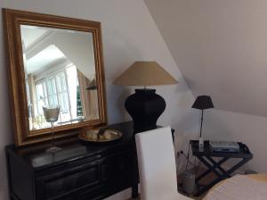 a bedroom with a mirror and a lamp on a dresser at Perle am Munkmarscher Watt in Munkmarsch