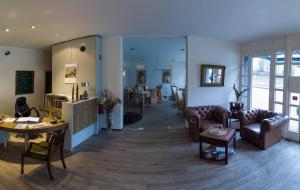 a living room with couches and a dining room at Hotel am Schloss Broich in Mülheim an der Ruhr