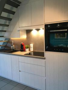 a kitchen with a sink and a microwave at House & garden l'Hippodrome in Bredene