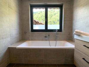 a bath tub in a bathroom with a window at Chalet See Tirol - Ischgl/Kappl in See +33 photos