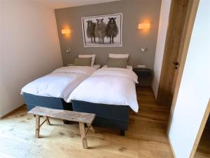 a room with two beds and a bench in it at Chalet See Tirol - Ischgl/Kappl in See