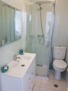 a bathroom with a toilet and a sink and a shower at See U Inn in Torreira