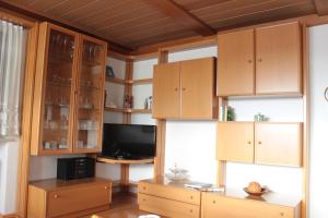 a living room with wooden cabinets and a television at Ferienwohnung Gegenfurtner in Böbrach
