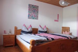 a bedroom with a wooden bed with shoes on it at Ferienwohnung Gegenfurtner in Böbrach