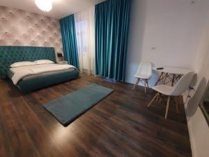 a bedroom with a bed and a table and chairs at GARSONIERRE CENTRAL LUXURY in Târgu Jiu