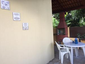 a table and chairs on a patio with signs on the wall at Pousada Recanto das Pedras São Leopoldo in Pirenópolis