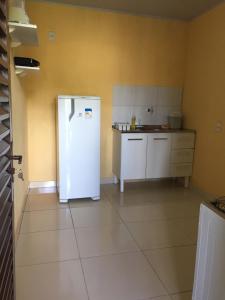 uma cozinha com um frigorífico branco num quarto em Pousada Recanto das Pedras São Leopoldo em Pirenópolis