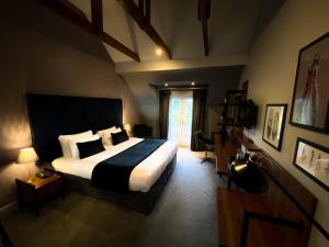 a bedroom with a large bed and a window at The Chesterton Hotel in Bicester