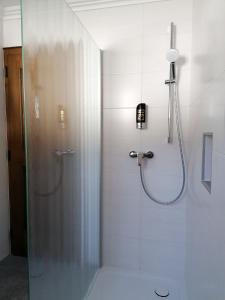 アプテナウにあるAppartementhaus Oberlehenのバスルーム(ガラスドア付きのシャワー付)