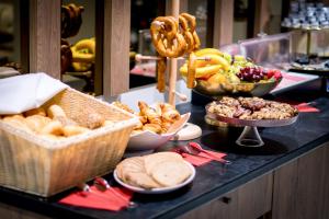 a buffet with various types of bread and baskets of food at Hotel Wilder Mann in Rückersdorf
