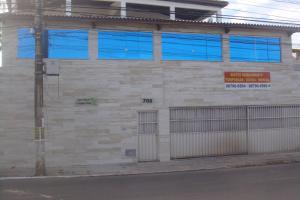 ein Gebäude mit blauen Fenstern auf der Straßenseite in der Unterkunft stellamares apartamentos in Salvador