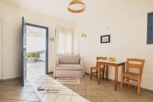 a living room with a chair and a table at Glaros luxury studio on the Beach in Arkasa
