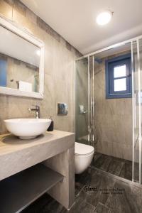 a bathroom with a sink and a shower and a toilet at Glaros luxury studio on the Beach in Arkasa +18 photos