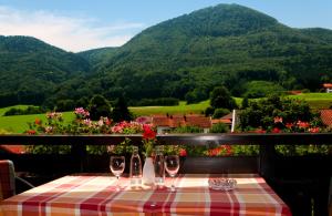 a table with wine glasses and a view of mountains at Gasthof Fischerstüberl in Rottau