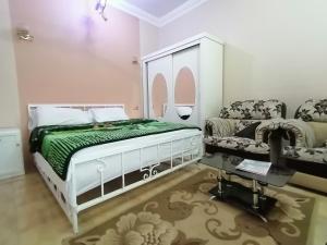 a bedroom with a bed and a couch and a chair at Luxor palace Apartments in Luxor