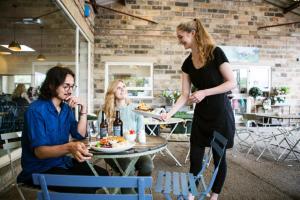 3 Personen sitzen an einem Tisch in einem Restaurant in der Unterkunft Hassop Station rooms on the Monsal Trail in Bakewell