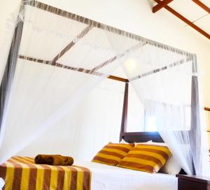 Schlafzimmer mit einem Bett mit gelben und weißen Streifen in der Unterkunft Beach Breeze Weligama in Weligama