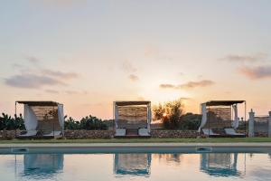 a pool with the sunset in the background at Masseria Cisternella in Alliste