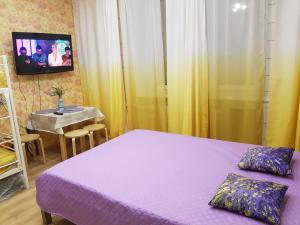クロンシュタットにあるViktoriaのベッドルーム(紫色のベッド1台、テレビ付きのテーブル付)