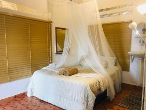 a bedroom with a bed with a mosquito net at Dar Yasmine Motel in Pantai Cenang +66 photos
