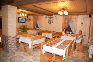 two women sitting at tables in a restaurant at Zelena Dacha in Dragobrat