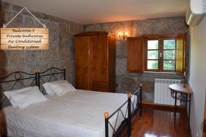 1 dormitorio con cama y ventana en Quinta da Várzea de Cima, en Marco de Canaveses