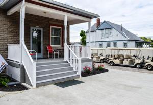a house with a porch with a white staircase at All Star Ohio House in Put-in-Bay
