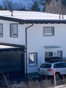 una macchina bianca parcheggiata di fronte a una casa di Haus Schladming a Schladming