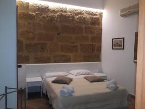 a bedroom with a bed and a brick wall at B&B Kolymbetra in Agrigento