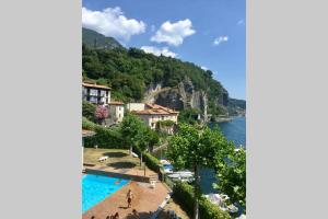 uma vista para um resort e um corpo de água em Mamma Ciccia - Lake front apartment, beach and swimming pool em Lierna