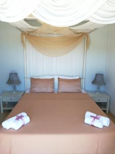 a bedroom with a large bed with two towels on it at Villa Kampos Naousa-Marpisa in Ambelas