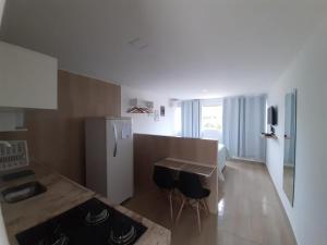 a kitchen with a refrigerator and a table and chairs at Pousada Belo Recanto - Pipa in Pipa