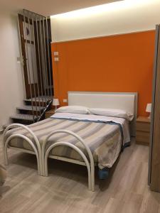 リエーティにあるB&B "La Camelia"のベッドルーム1室(オレンジ色の壁のベッド1台付)