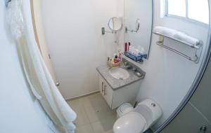 een badkamer met een wastafel, een toilet en een spiegel bij Confortable y Tranquilo Aparta Suite en el Corazón de Bucaramanga, Exterior con hermosa vista sobre la ciudad in Bucaramanga