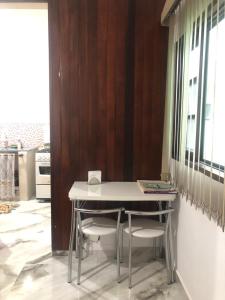 a table and chairs in a room with a kitchen at Cantinho da Lu em apt inteiro 800 mt da praia in Bertioga