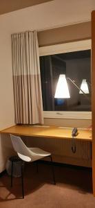 a room with a chair and a lamp in it at Sure Hotel by Best Western Spånga in Stockholm