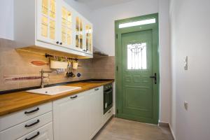 een groene deur in een keuken met een wastafel bij EGLI LUXURY APARTMENTS in Archangelos