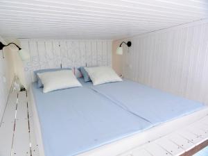 a white bed in a room with two pillows at Tiny Glamping Holiday Houses in Ercsi