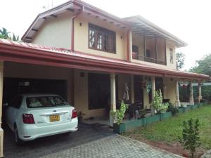 a white car parked in front of a house at Ceylon Epic Inn in Bentota