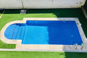 una vista aérea de una piscina azul con césped en Apartamento con piscina y terraza al lado de la playa, en Baiona