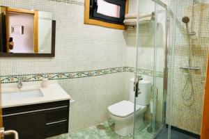 ein Bad mit einem WC, einem Waschbecken und einer Dusche in der Unterkunft Apartamento con piscina y terraza al lado de la playa in Baiona